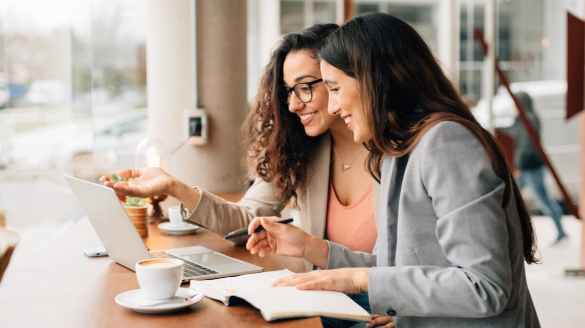 deux femmes travaillant en coworking dans un café