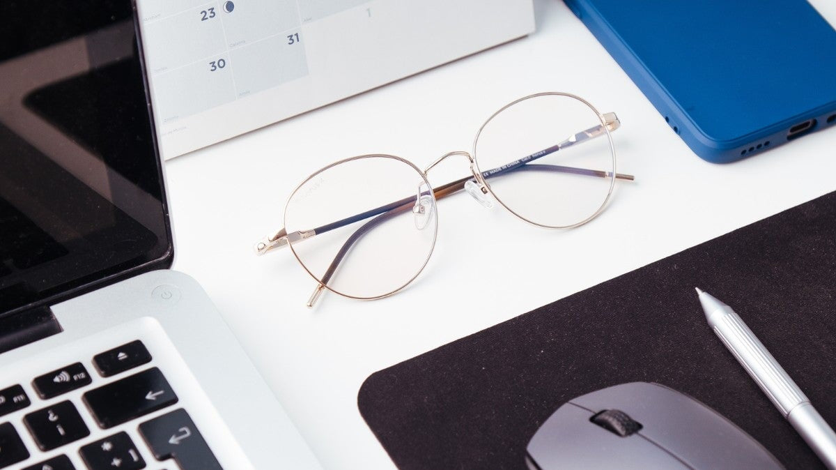 lunettes anti-lumière bleue horus x sur une table avec un ordinateur portable et une souris