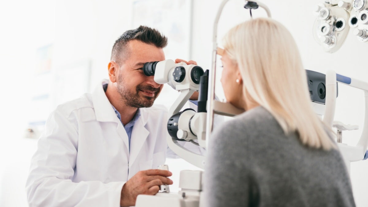 ophtalmologiste vérifiant l'œil d'une femme