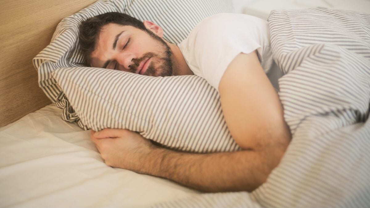 un homme qui dort dans son lit