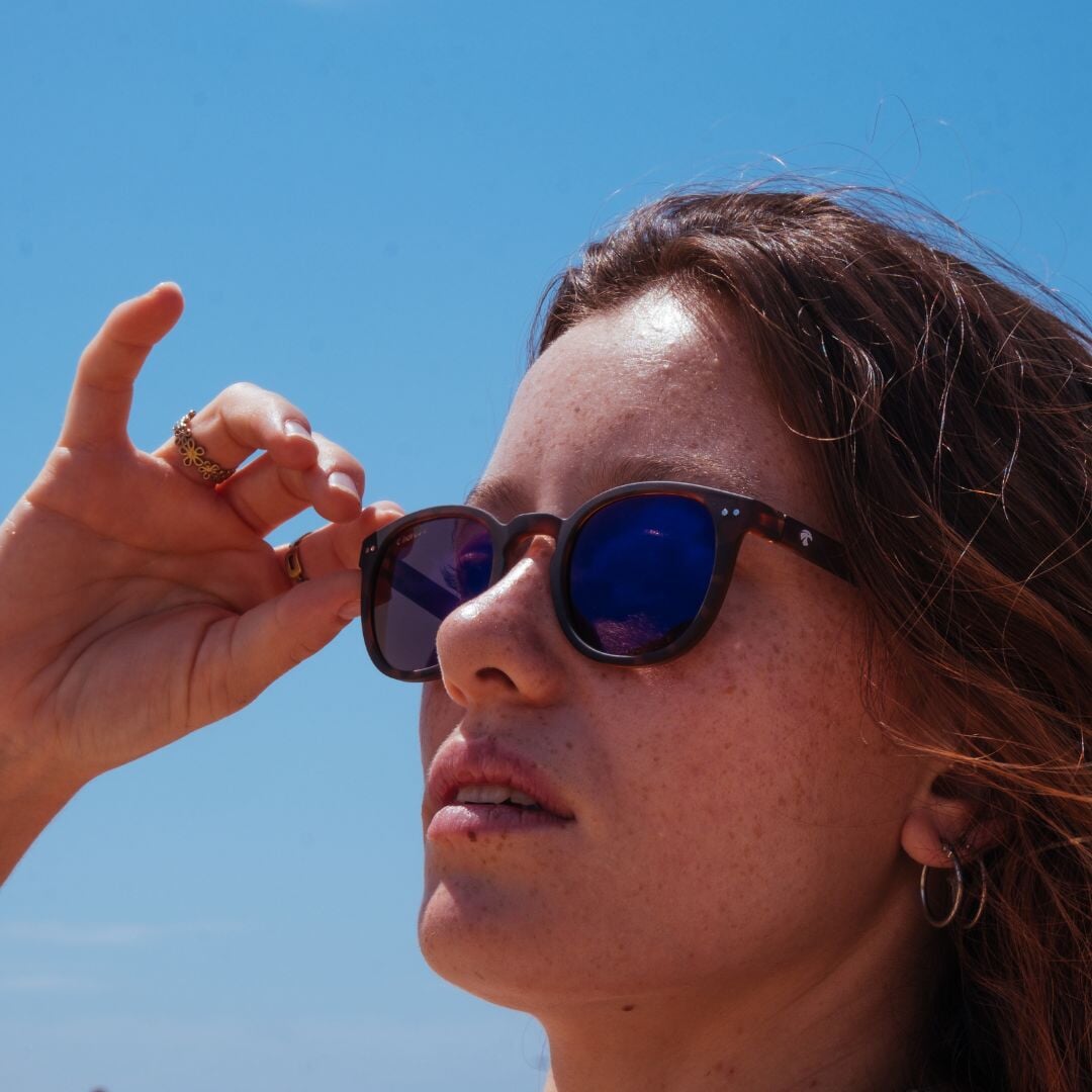 Emma porte les stockholm sun anti lumière bleue solaires sur fond ciel bleu