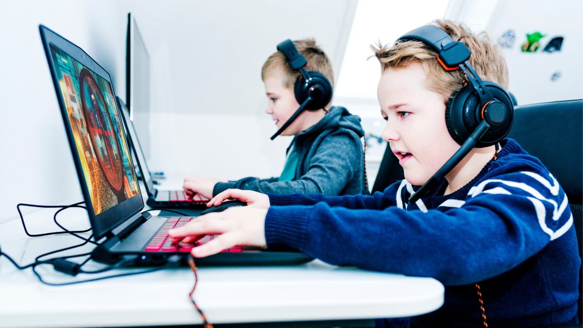 Les enfants jouent à des jeux vidéo avec des ordinateurs portables et des écouteurs de jeu