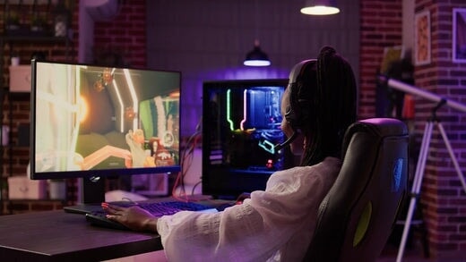 une gameuse utilisant une configuration de jeu sur PC s'amusant à jouer à un jeu d'action multijoueur en ligne