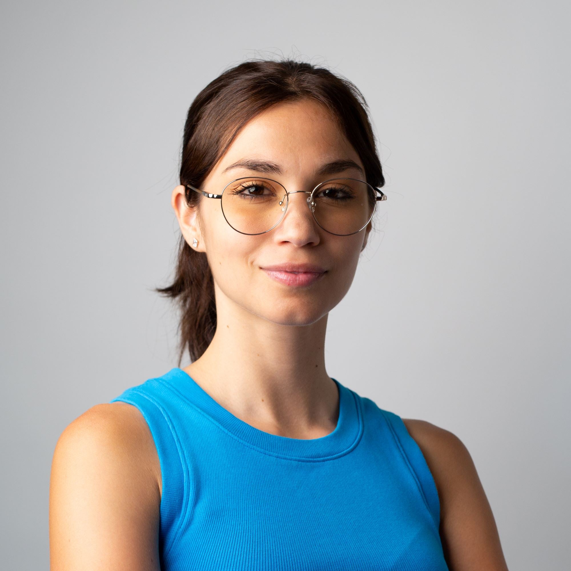 Portrait d'une femme qui porte les lunettes anti lumière bleue rondes en métal doré Ushuaia. 