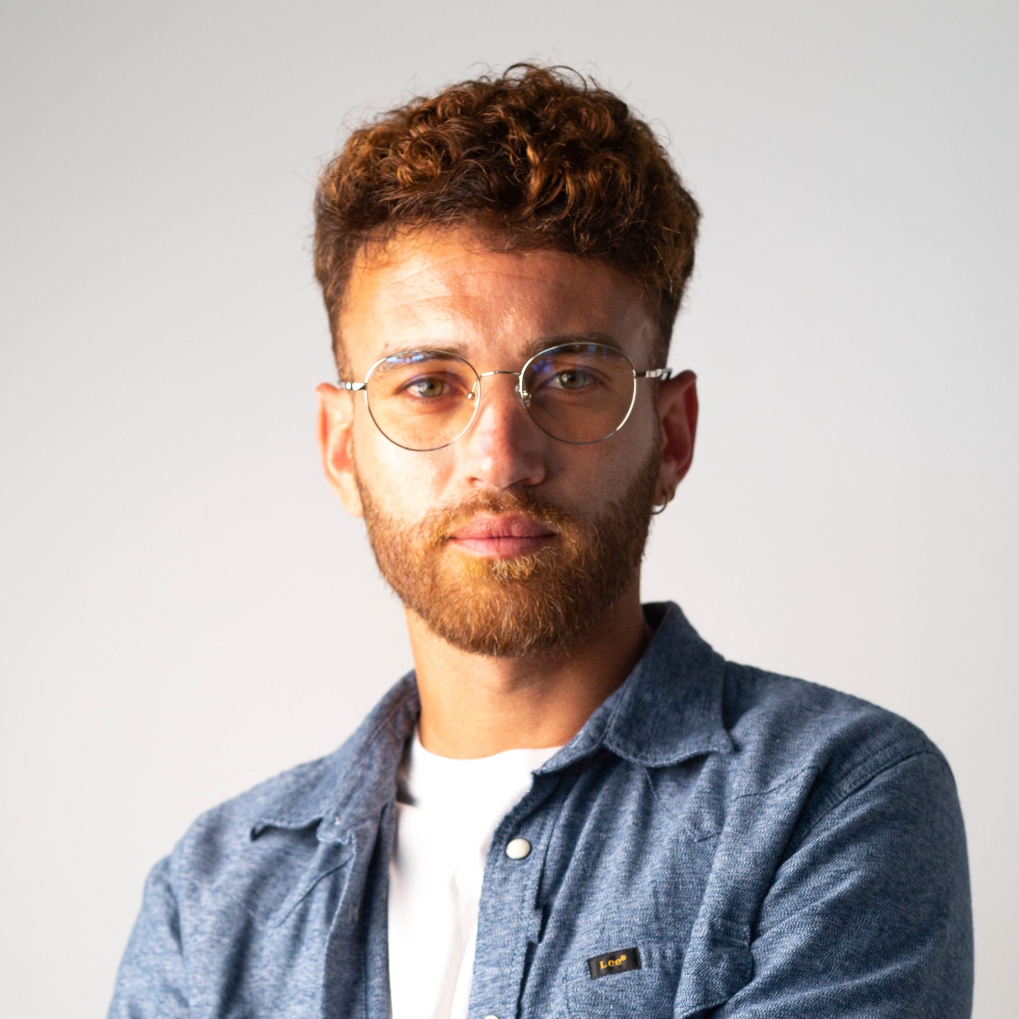 Portrait d'un homme qui porte les lunettes anti lumière bleue rondes en métal doré Ushuaia. 