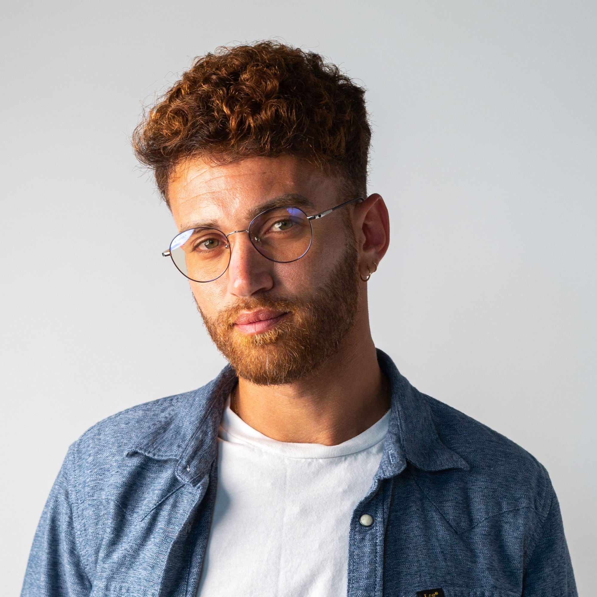 Portrait d'un homme qui porte les lunettes anti lumière bleue rondes en métal argenté Ushuaia. 