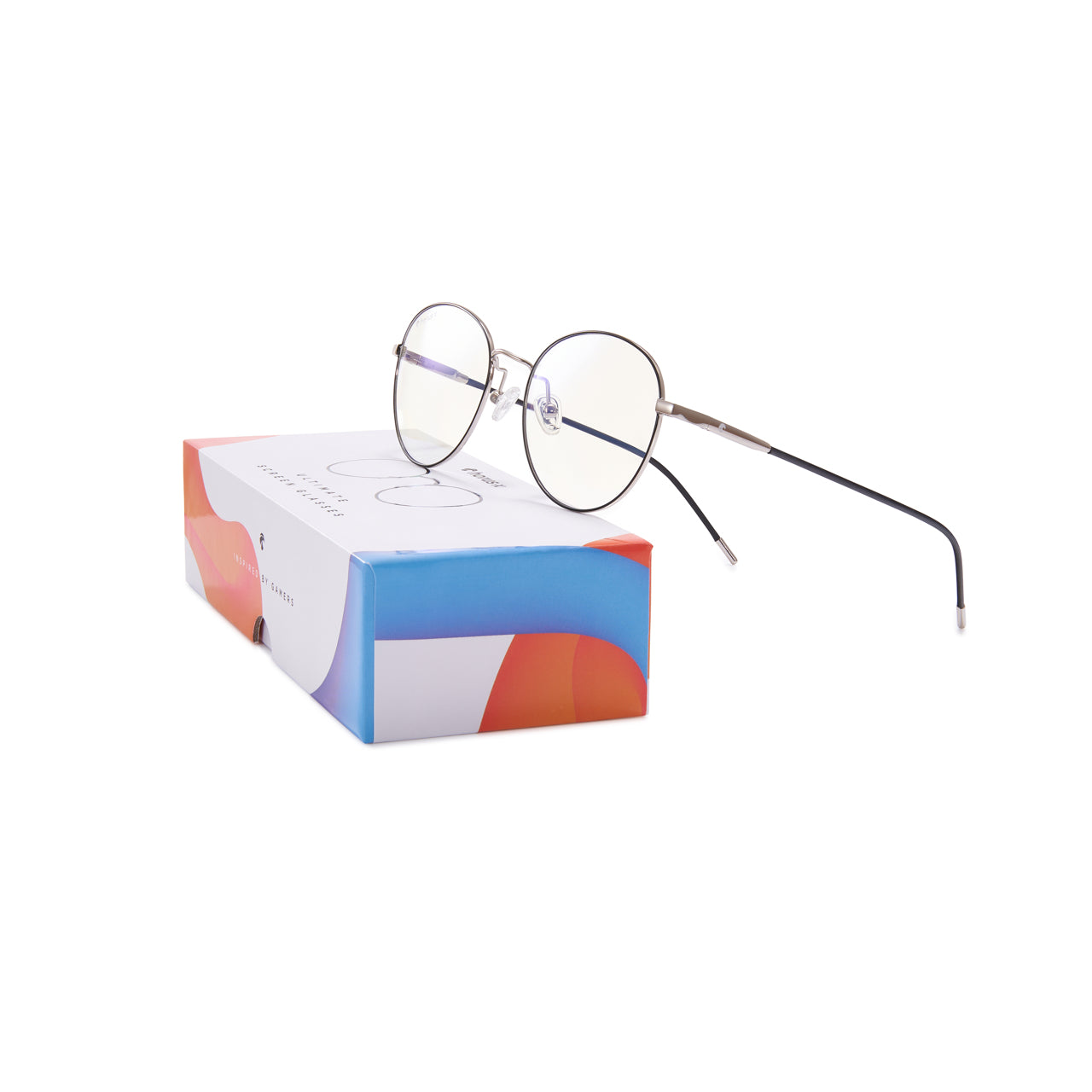 Lunettes anti lumière bleue rondes aux branches marrons, en métal argenté, posées sur leur emballage coloré cartonné de 3/4 